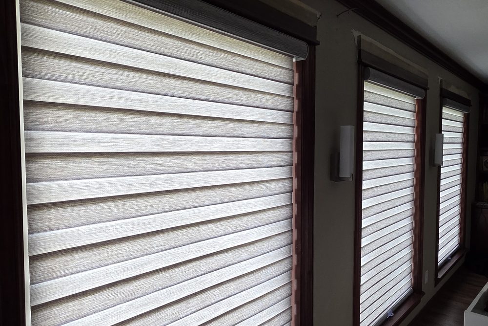 Custom tan dual sheer shades installed along a wood-trimmed hallway